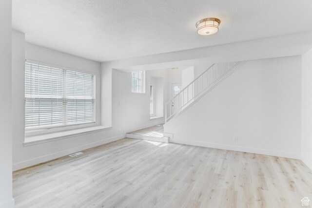 415 E Acoma Rd S, Midvale, UT 84047 - unfurnished living room featuring wood finished floors and stairway