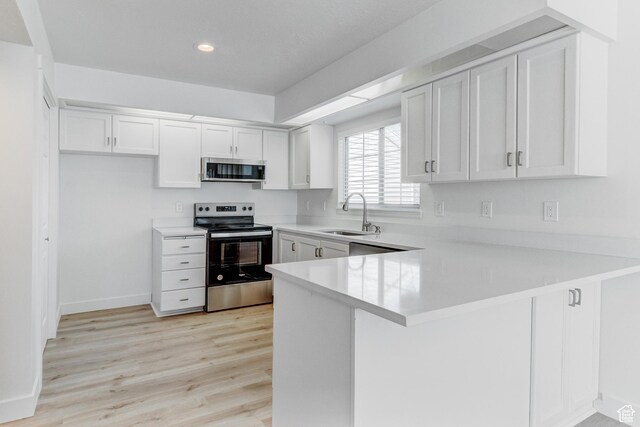 415 E Acoma Rd S, Midvale, UT 84047 - kitchen featuring stainless steel appliances, a peninsula, light countertops, white cabinets, and recessed lighting