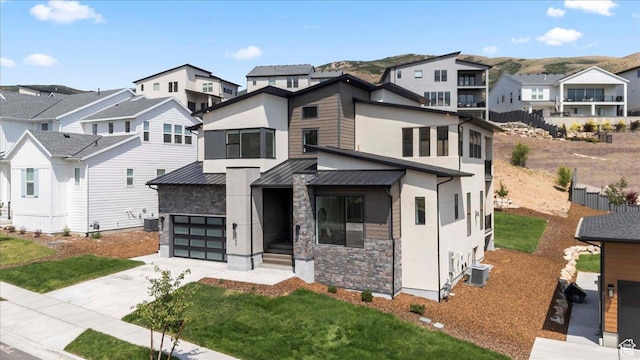 5554 N Fox Canyon Rd, Lehi, UT 84043 - contemporary home with a residential view, a garage, stone siding, a standing seam roof, and driveway