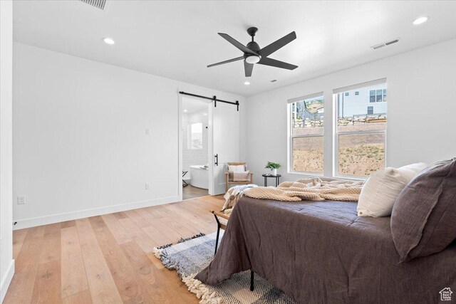 5554 N Fox Canyon Rd, Lehi, UT 84043 - bedroom with a barn door, light wood-style floors, recessed lighting, ensuite bathroom, and a ceiling fan