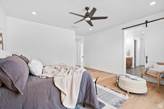 5554 N Fox Canyon Rd, Lehi, UT 84043 - bedroom featuring wood finished floors, a barn door, recessed lighting, ceiling fan, and connected bathroom