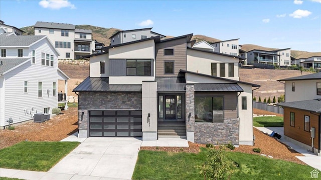 5554 N Fox Canyon Rd, Lehi, UT 84043 - contemporary house with stone siding, a standing seam roof, a residential view, an attached garage, and driveway