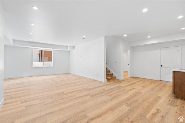 5554 N Fox Canyon Rd, Lehi, UT 84043 - unfurnished living room with stairs, light wood-style floors, and recessed lighting