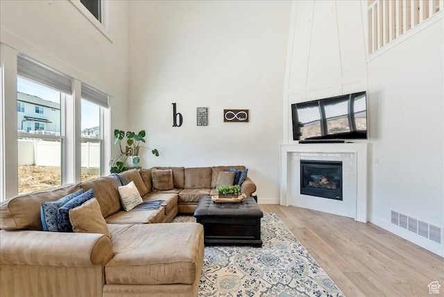 2847 S Puddle Ln S, Saratoga Springs, UT 84045 - living room with a high ceiling, light wood finished floors, and a glass covered fireplace