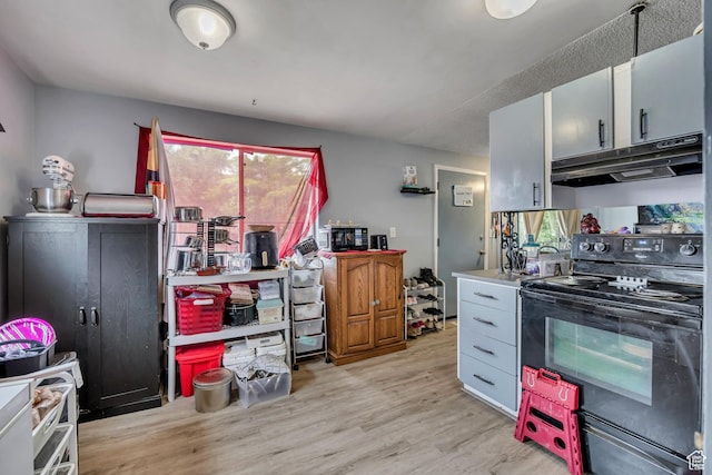 222 W Center St S, Midvale, UT 84047 - kitchen with black range with electric stovetop, under cabinet range hood, and light wood-style flooring