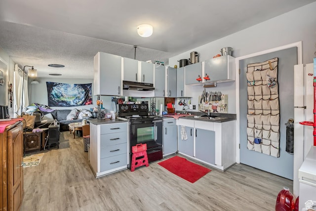 222 W Center St S, Midvale, UT 84047 - kitchen with black range with electric cooktop, under cabinet range hood, light wood-style floors, and open floor plan
