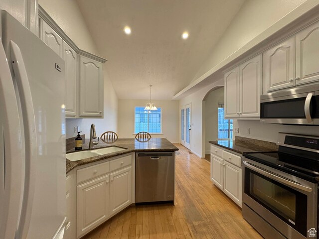 511 W 40 N, Orem, UT 84057 - kitchen featuring stainless steel appliances, lofted ceiling, recessed lighting, dark stone countertops, and arched walkways