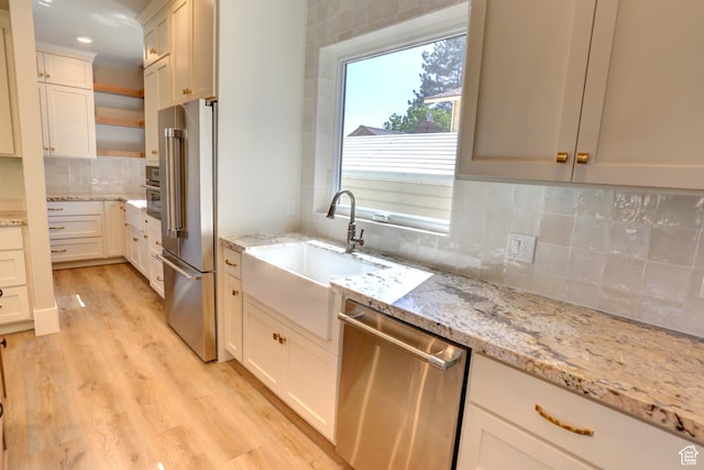 435 E Maple St, Mapleton, UT 84664 - kitchen featuring appliances with stainless steel finishes, backsplash, light wood-style flooring, light stone counters, and open shelves
