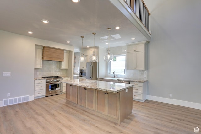 435 E Maple St, Mapleton, UT 84664 - kitchen with high quality appliances, backsplash, a center island, recessed lighting, and light wood-style floors