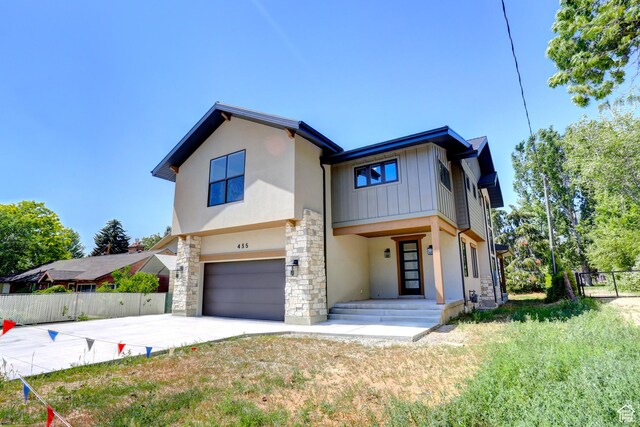 435 E Maple St, Mapleton, UT 84664 - view of front of house featuring stone siding, an attached garage, concrete driveway, stucco siding, and board and batten siding