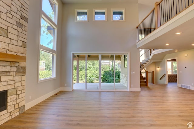 435 E Maple St, Mapleton, UT 84664 - unfurnished living room featuring a towering ceiling, wood finished floors, stairs, recessed lighting, and a fireplace