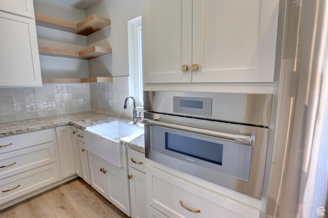 435 E Maple St, Mapleton, UT 84664 - kitchen featuring open shelves, oven, white cabinetry, decorative backsplash, and light stone counters