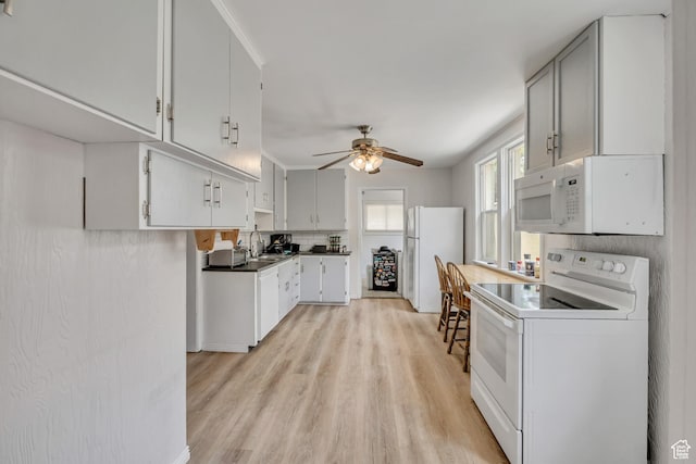 733 E Linden Ave, Salt Lake City, UT 84102 - kitchen with white appliances, ceiling fan, light wood-style flooring, dark countertops, and backsplash