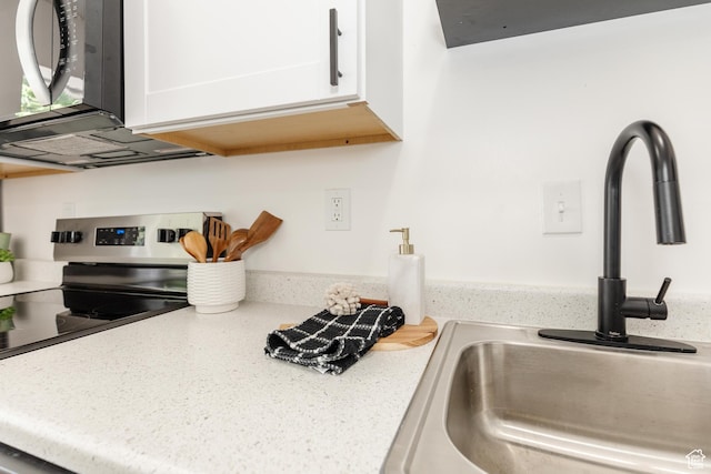 221 E 8th S, Ogden, UT 84401 - kitchen with stainless steel range with electric stovetop, white cabinets, and light stone countertops