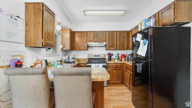 636 Downs Dr, Ogden, UT 84404 - kitchen featuring freestanding refrigerator, under cabinet range hood, stainless steel electric range oven, a peninsula, and brown cabinets