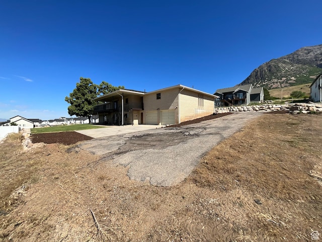 3696 N 475 E, North Ogden, UT 84414 - back of house with a mountain view, driveway, an attached garage, and concrete block siding