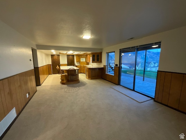 3696 N 475 E, North Ogden, UT 84414 - kitchen with brown cabinets, a wainscoted wall, light countertops, glass insert cabinets, and wood walls