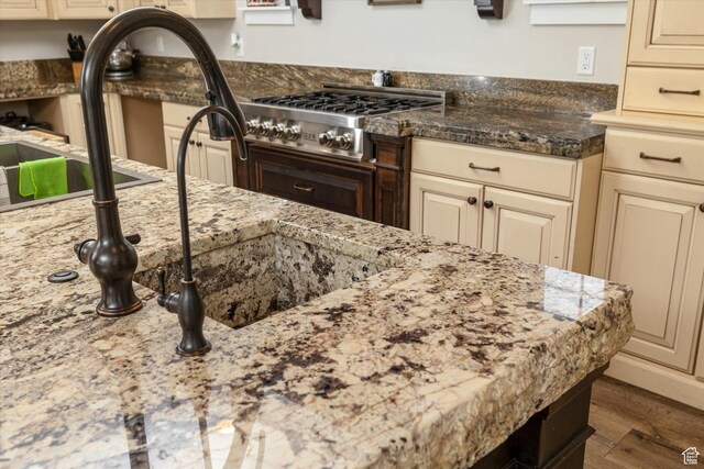 689 W Dee Dr, Garden City, UT 84028 - kitchen featuring cream cabinets, stainless steel gas stovetop, wood finished floors, and light stone countertops
