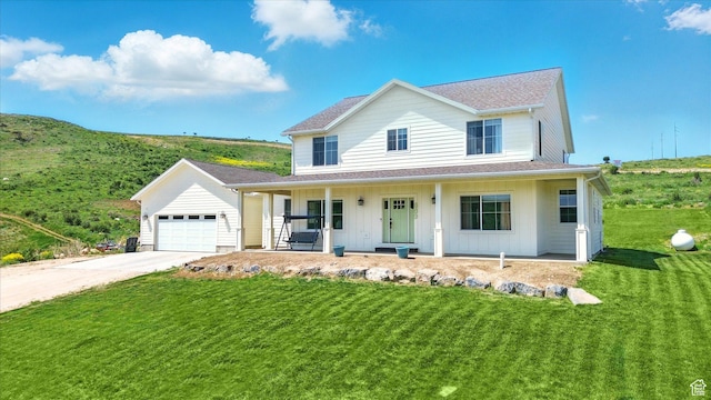 689 W Dee Dr, Garden City, UT 84028 - view of front of home featuring covered porch, concrete driveway, an attached garage, a front yard, and roof with shingles