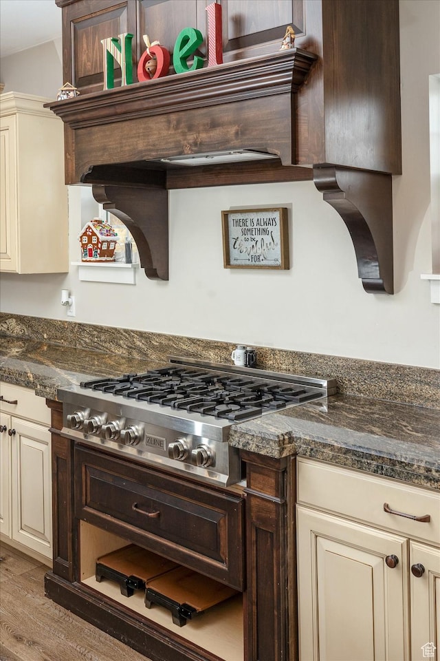 689 W Dee Dr, Garden City, UT 84028 - kitchen with cream cabinetry, stainless steel gas stovetop, light wood-type flooring, and dark stone counters