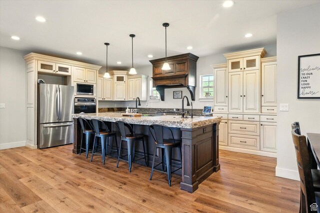 689 W Dee Dr, Garden City, UT 84028 - kitchen featuring appliances with stainless steel finishes, cream cabinets, a spacious island, light wood-style floors, and recessed lighting