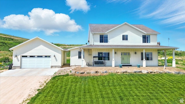 689 W Dee Dr, Garden City, UT 84028 - view of front of property featuring covered porch, concrete driveway, a front yard, a shingled roof, and board and batten siding