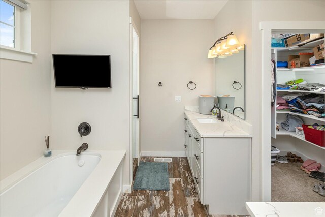 689 W Dee Dr, Garden City, UT 84028 - bathroom with vanity, a bath, and wood finished floors