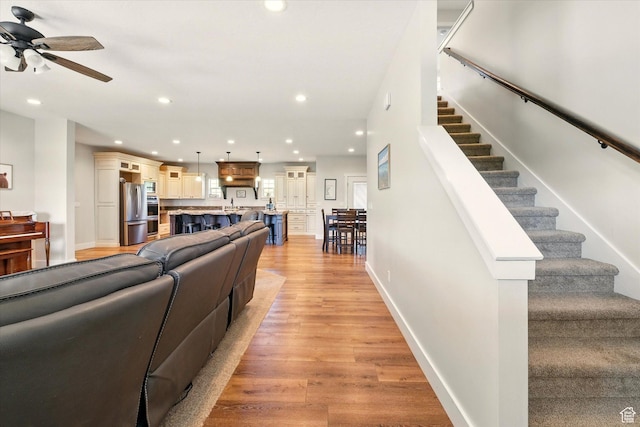 689 W Dee Dr, Garden City, UT 84028 - living room featuring light wood finished floors, a ceiling fan, stairway, and recessed lighting