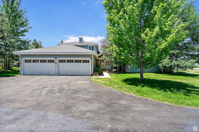 2125 E Elk Meadow Cir, Kamas, UT 84036 - view of front of home with a front lawn, driveway, a chimney, a garage, and a shingled roof