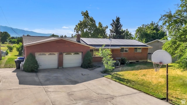 185 S 200 W, Providence, UT 84332 - ranch-style home featuring a front yard, driveway, roof mounted solar panels, an attached garage, and a mountain view