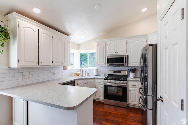 14048 S Van Cott Peak Cir W, Riverton, UT 84096 - kitchen with appliances with stainless steel finishes, a peninsula, lofted ceiling, white cabinetry, and decorative backsplash