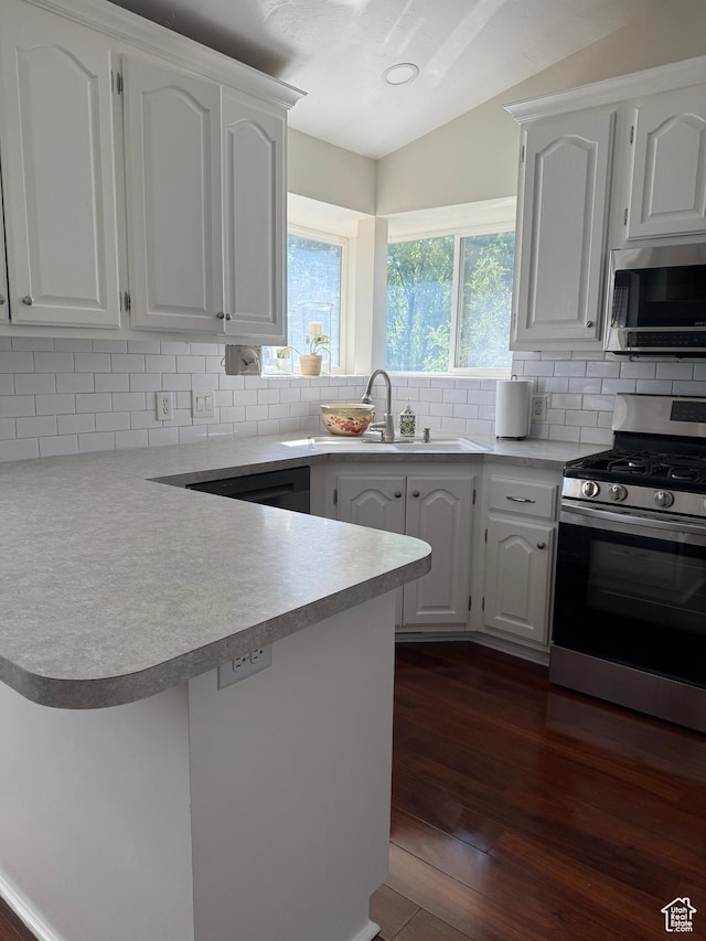 14048 S Van Cott Peak Cir W, Riverton, UT 84096 - kitchen featuring stainless steel appliances, a peninsula, dark wood-type flooring, white cabinetry, and decorative backsplash