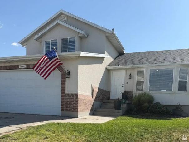 14048 S Van Cott Peak Cir W, Riverton, UT 84096 - tri-level home featuring brick siding, stucco siding, a front yard, and driveway