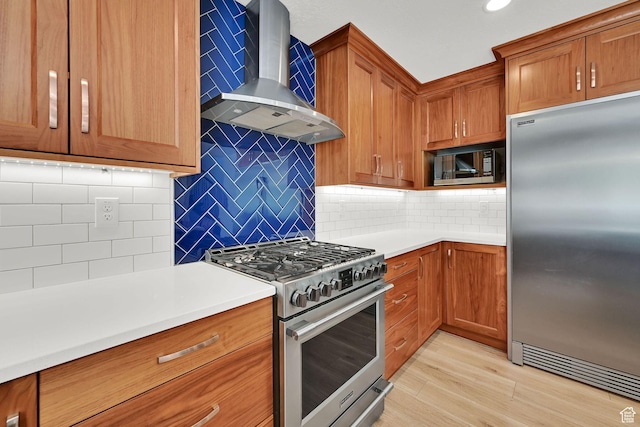 6699 E 950 S, Huntsville, UT 84317 - kitchen with appliances with stainless steel finishes, wall chimney exhaust hood, tasteful backsplash, brown cabinets, and recessed lighting