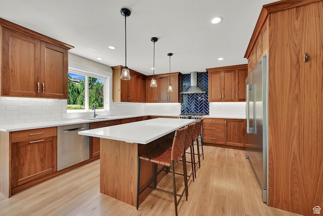 6699 E 950 S, Huntsville, UT 84317 - kitchen with stainless steel appliances, wall chimney exhaust hood, light wood finished floors, brown cabinets, and a kitchen breakfast bar