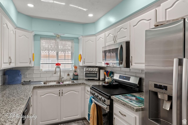 180 N 1100 E Unit 190, Washington, UT 84780 - kitchen with stainless steel appliances, decorative backsplash, white cabinets, recessed lighting, and a textured ceiling