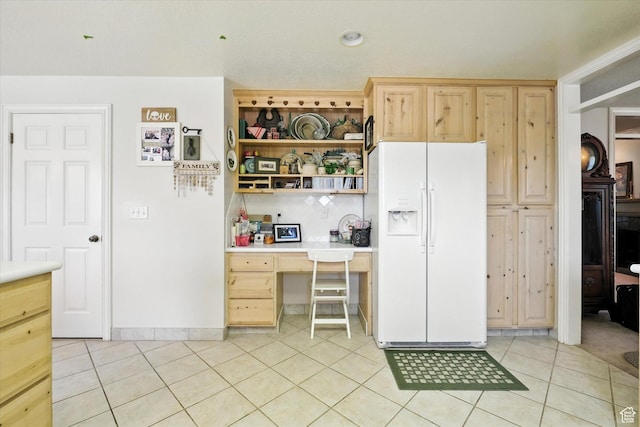 36 N Main St, Mantua, UT 84324 - kitchen with white refrigerator with ice dispenser, built in study area, light brown cabinets, and light tile patterned flooring