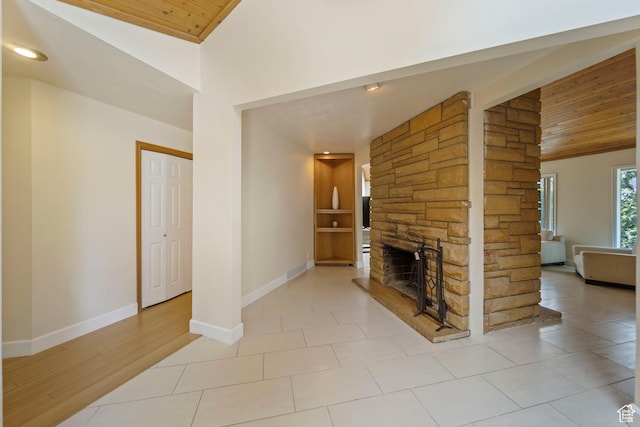 8463 S Jackson Hole Dr E, Sandy, UT 84093 - unfurnished living room with vaulted ceiling, wooden ceiling, a stone fireplace, and light tile patterned flooring