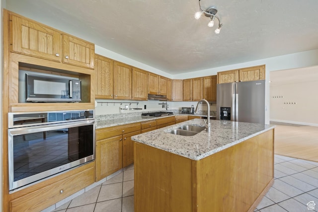 8463 S Jackson Hole Dr E, Sandy, UT 84093 - kitchen with appliances with stainless steel finishes, light tile patterned floors, an island with sink, and light stone counters