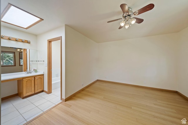 8463 S Jackson Hole Dr E, Sandy, UT 84093 - additional living space with light wood-type flooring, ceiling fan, a skylight, and an office area