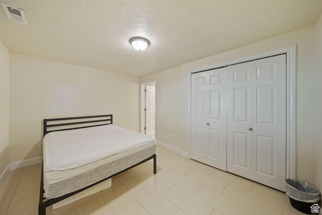 8463 S Jackson Hole Dr E, Sandy, UT 84093 - bedroom featuring a textured ceiling, a closet, and light tile patterned floors