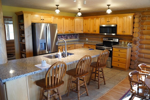 11495 E 16000 N, Mount Pleasant, UT 84647 - kitchen featuring stainless steel appliances, rustic walls, a kitchen bar, hanging light fixtures, and light stone counters