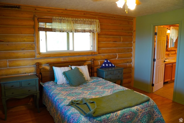 11495 E 16000 N, Mount Pleasant, UT 84647 - bedroom with rustic walls, light wood-type flooring, a textured ceiling, and ensuite bath