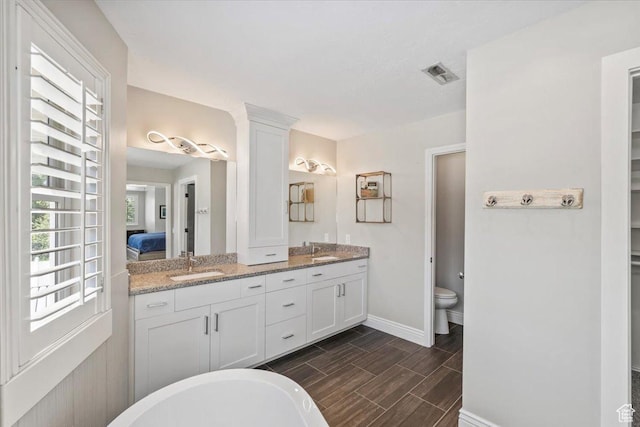 4104 S Bridlewood Dr E, Bountiful, UT 84010 - full bath featuring double vanity, a freestanding tub, wood tiled floors, and connected bathroom