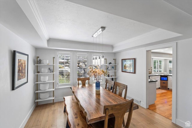 4104 S Bridlewood Dr E, Bountiful, UT 84010 - dining space featuring a raised ceiling, crown molding, light wood-type flooring, and a textured ceiling