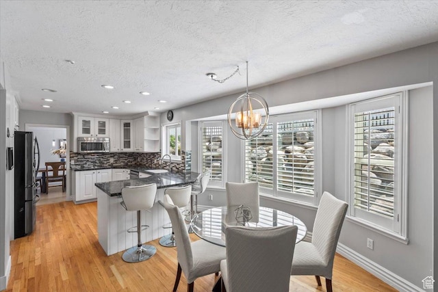 4104 S Bridlewood Dr E, Bountiful, UT 84010 - dining room with a textured ceiling, a chandelier, plenty of natural light, light wood finished floors, and recessed lighting