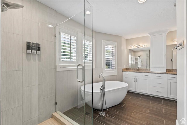4104 S Bridlewood Dr E, Bountiful, UT 84010 - full bath with vanity, a stall shower, a freestanding bath, and wood finish floors