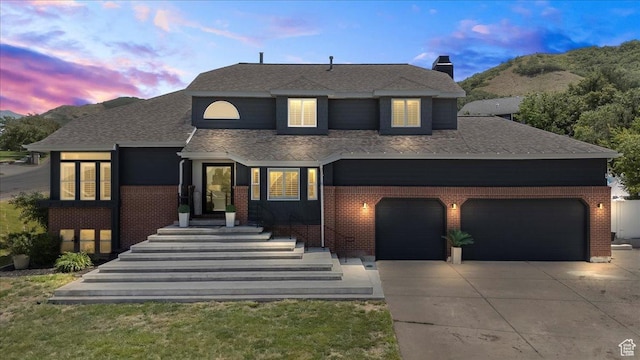 4104 S Bridlewood Dr E, Bountiful, UT 84010 - view of front facade with brick siding, concrete driveway, roof with shingles, a chimney, and a mountain view