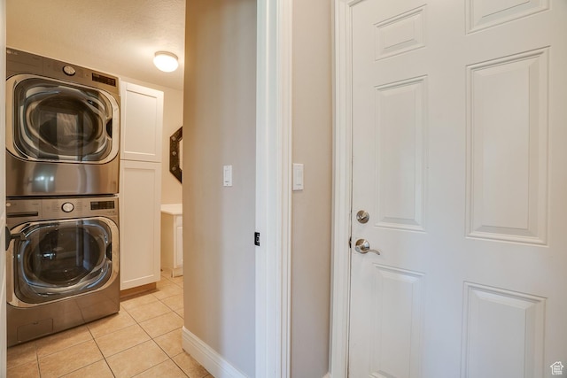 3035 S Big Hollow Rd, Heber City, UT 84032 - washroom with stacked washer and clothes dryer, cabinet space, and light tile patterned flooring