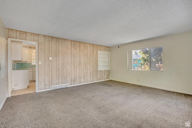 3409 S Maple Way, Salt Lake City, UT 84119 - carpeted empty room with a textured ceiling and wood walls